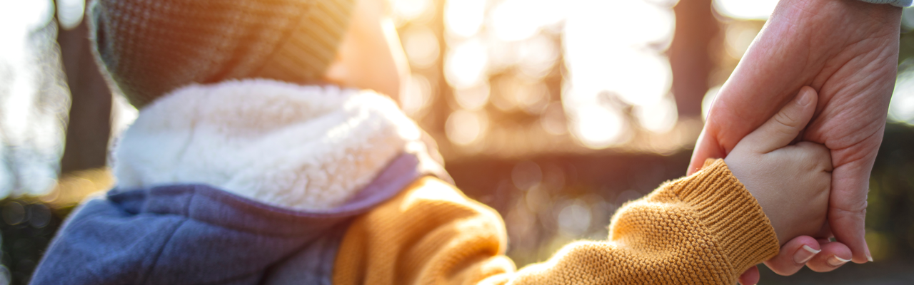 image of a guardian holding a child's hand